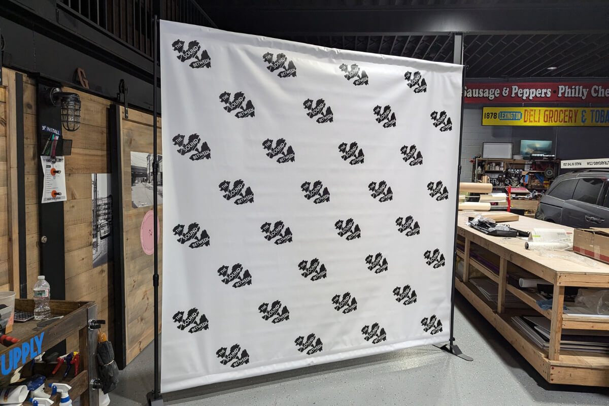 Custom white step and repeat backdrop with black repeating logos for brand activation